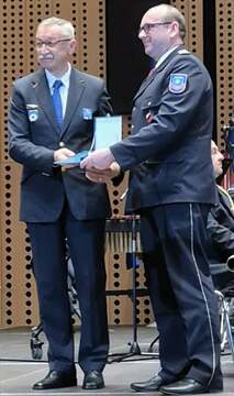 Prejemniki plakete CZ Koroški gasilski zavod, zanj Dejan Salčnik, na nacionalni slovesnosti ob dnevu Civilne zaščite, plaketo CZ jim je vročil poveljnik Civilne zaščite Republike Slovenije Srečko Šestan